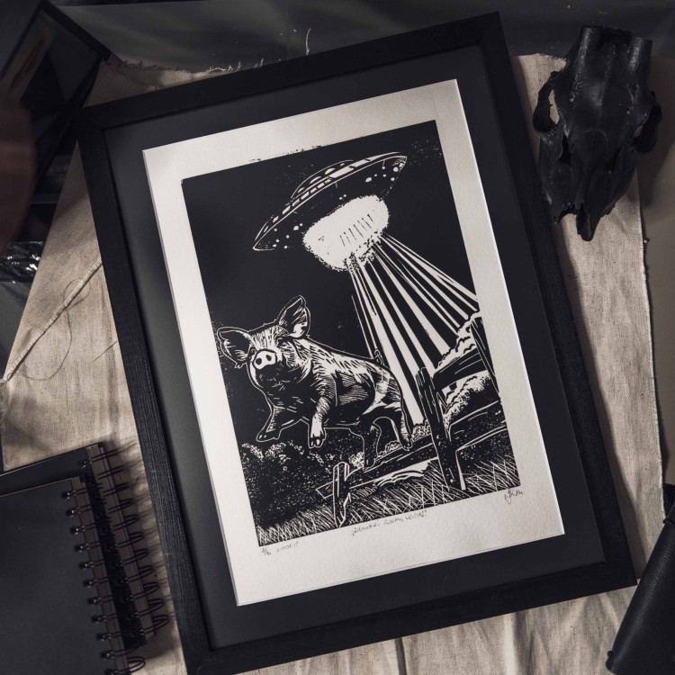 Autorski linoryt świnka skacząca przez ogrodzenie, humorystyczna grafika ręcznie wykonana, surrealistyczna dekoracja z motywem UFO